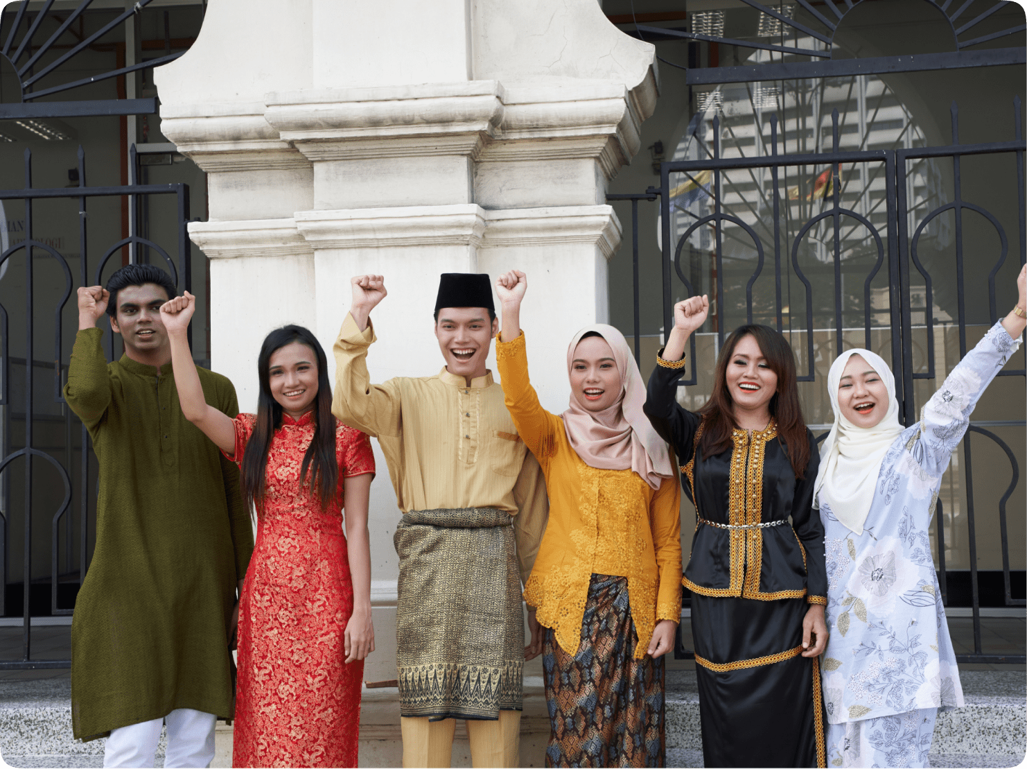 A group of young Malaysian people smiling and waving